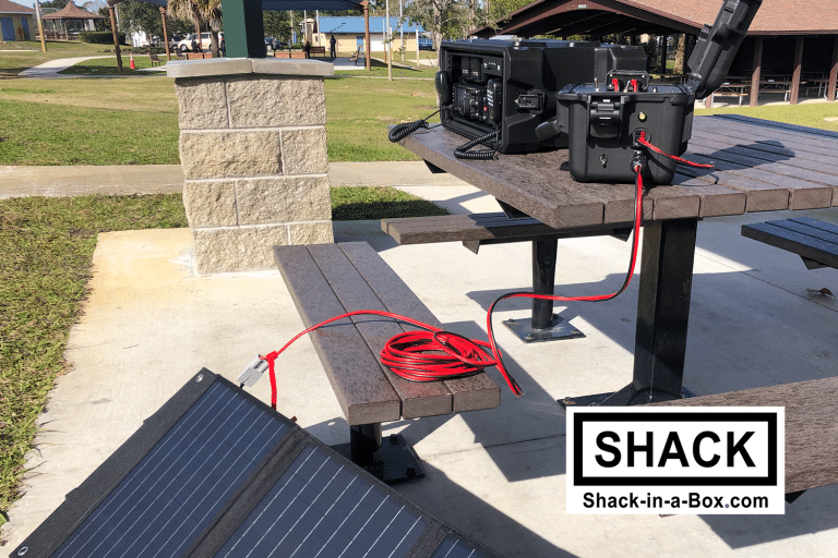 Yaesu All-in-One Go Box on a park picnic table with a solar panel and red power cable