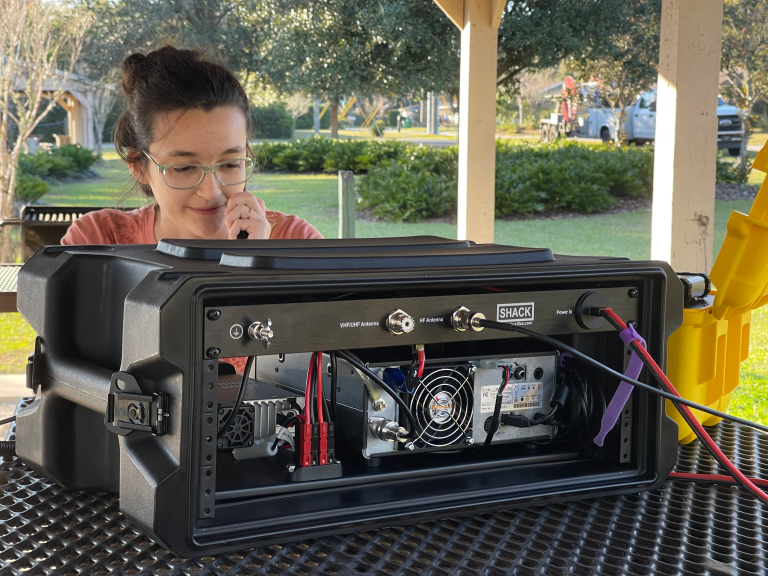 Operator talking on the radio behind a Shack-in-a-Box HF/VHF/UHF All-in-One Go Box